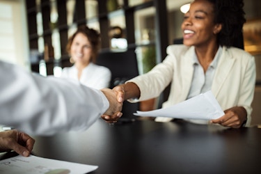  Business woman making agreement with an employee, shaking hands. 