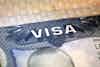 Close up shot of a travel visa with the word 'VISA' showing